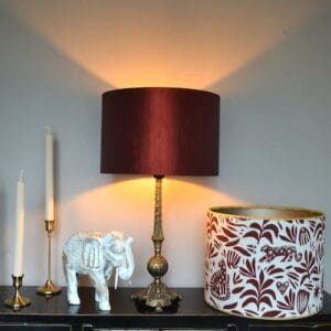 foto van een sfeervolle lamp met rode kap en een losse lampenkap in rood met beige patronen