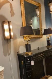 foto van een schouw met spiegel erop 2 hollywood regency lampen